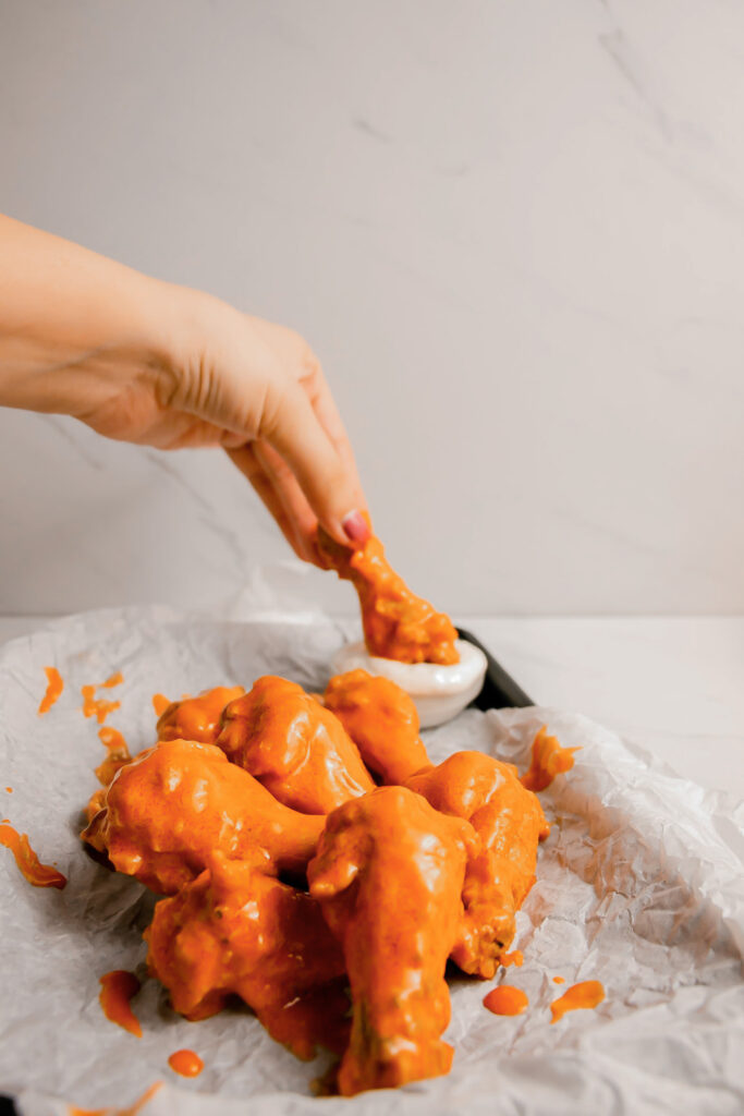 Homemade garlic buffalo wings on a tray dipped in ranch