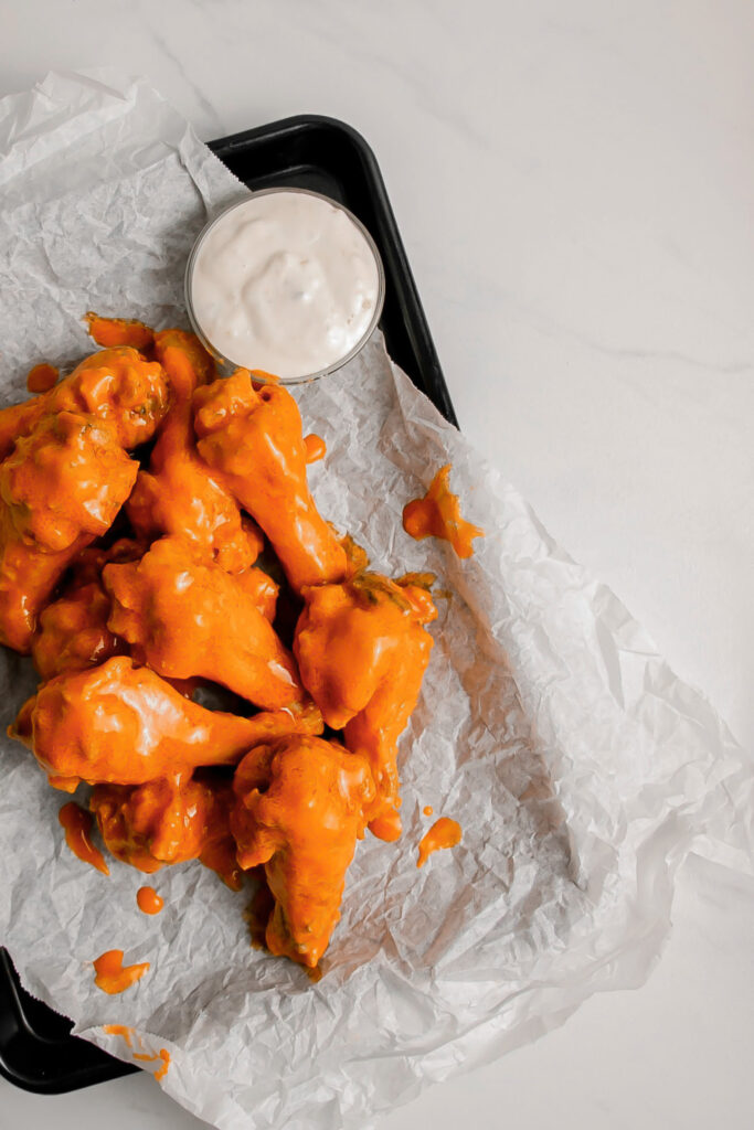 Homemade garlic buffalo wings on a tray with ranch