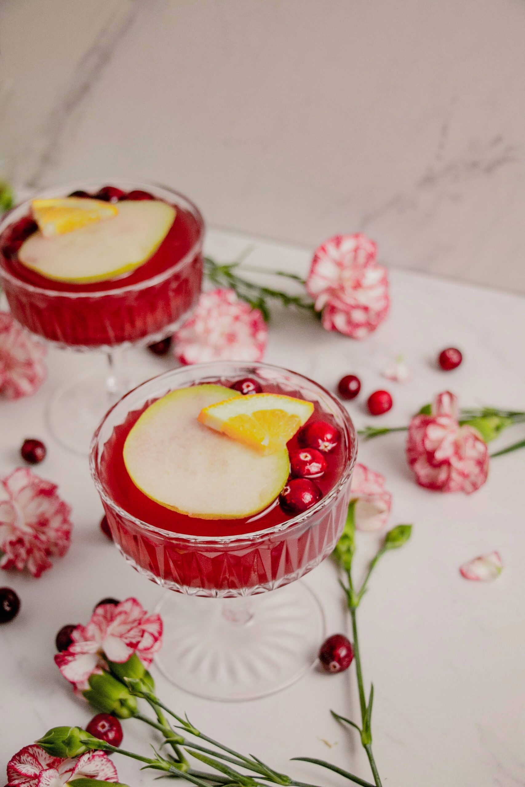 Rosé pear sangrias cocktails in coup glasses with flowers