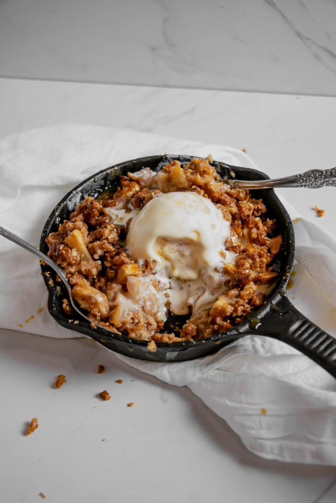 Homemade caramel apple crumble topped with ice cream side view