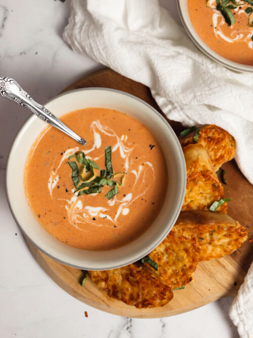 Homemade creamy tomato basil soup in bowls top view