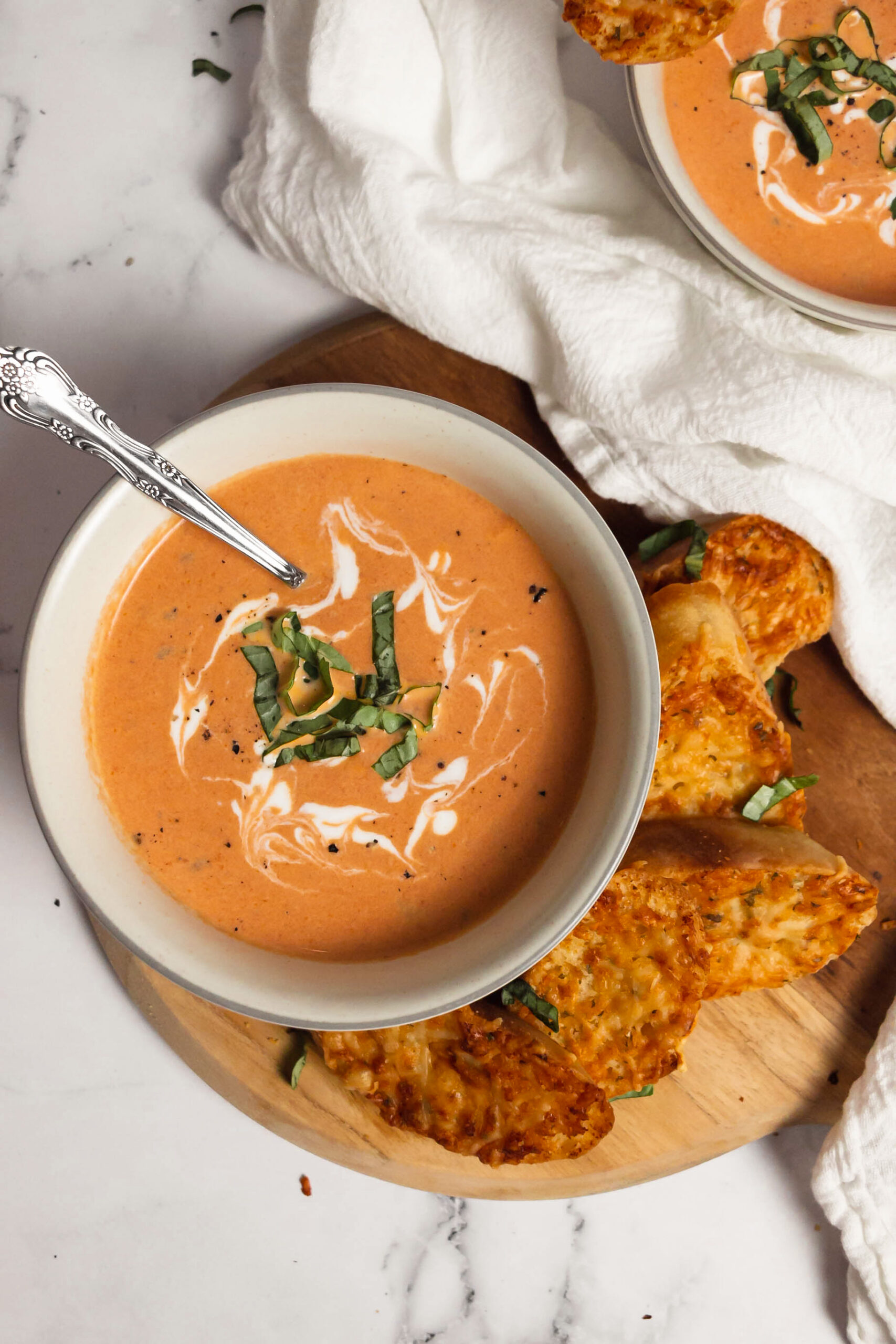 Homemade creamy tomato basil soup in bowls top view