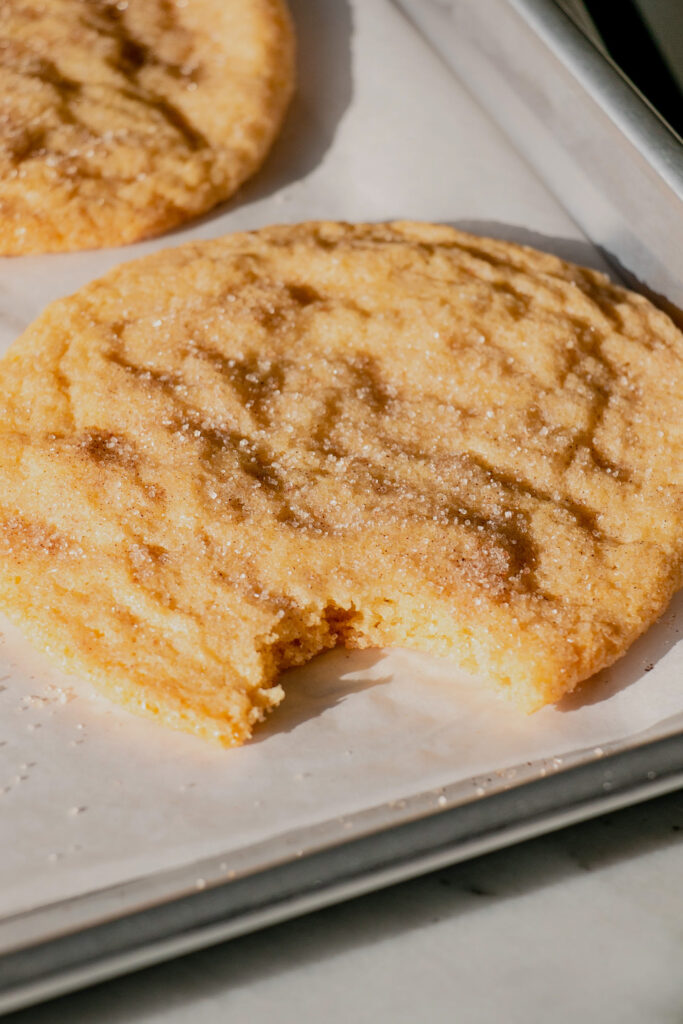 homemade jumbo snickerdoodle cookies with a bite taken from it