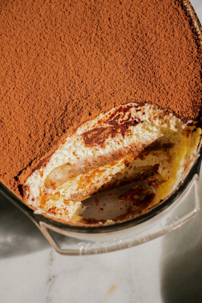 close up of a homemade tiramisu with a piece missing